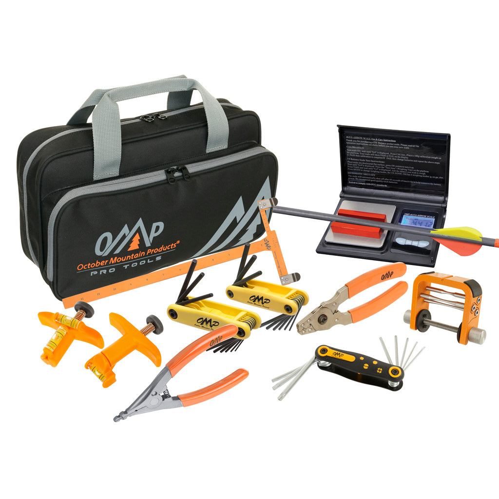 An archery tool kit laid out on white — black carry bag, orange-handled pliers and wrenches, folding hex sets, a small digital scale and a fletched arrow.